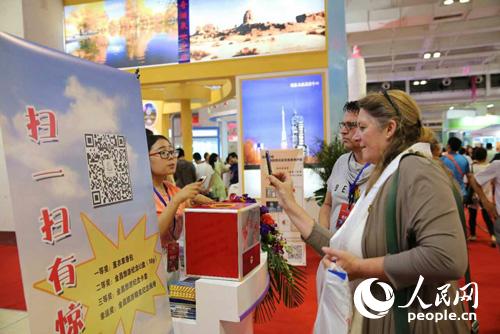 金昌旅游商品驚艷亮相絲綢之路旅游產(chǎn)品展(圖4) 外商參與金昌現(xiàn)場掃碼活動