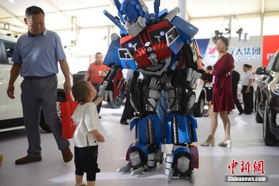 6月30日，車展上的“變形金剛”為主辦方造勢。當(dāng)日，2016第八屆呼和浩特國際汽車展覽會開幕，展會為期5天，國內(nèi)外近80個汽車品牌以及30多家汽配商企參展，同時還設(shè)有汽保、老爺車、金融、改裝以及汽車行業(yè)相關(guān)服務(wù)等展示區(qū)，參展車型近500余款。中新社記者